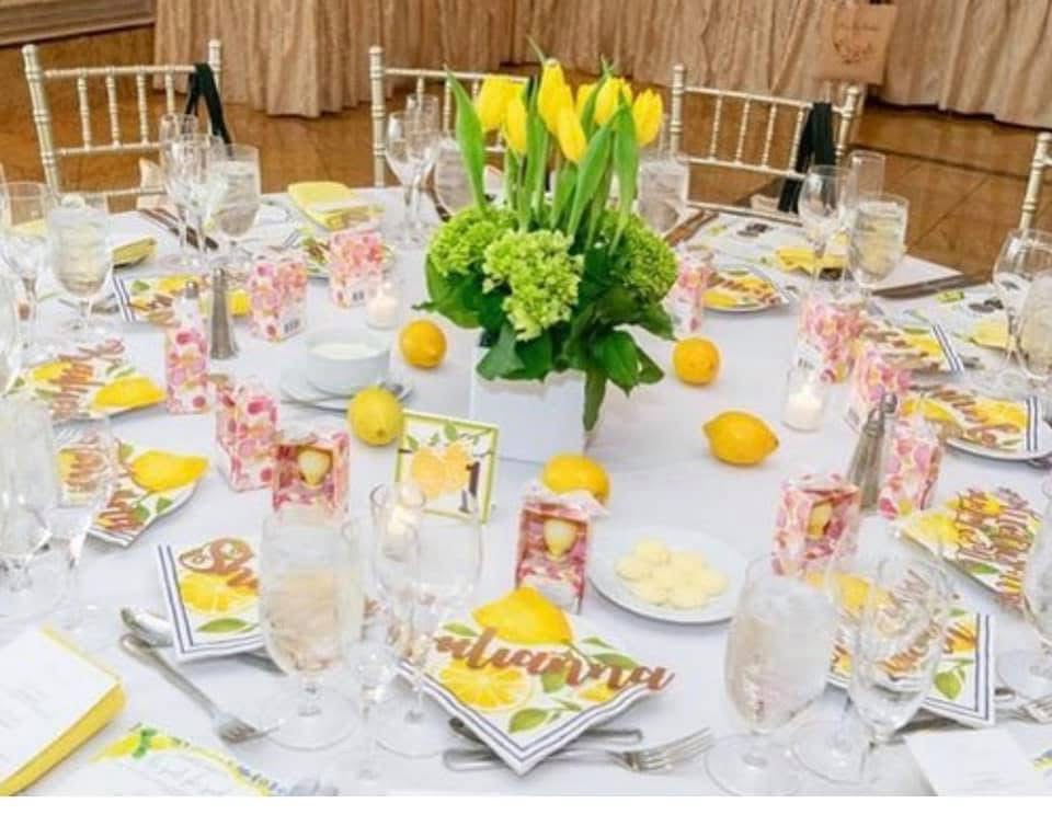 Luncheon table with yellow tulips and green hydrangea centerpiece surrounded by lemons and citrus place settings