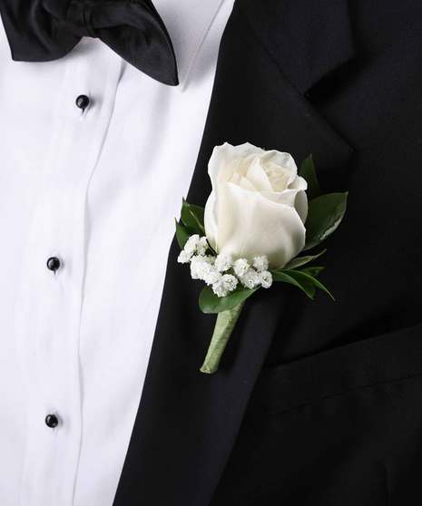 White rose boutonniere with baby's breath on a black tuxedo with a bow tie