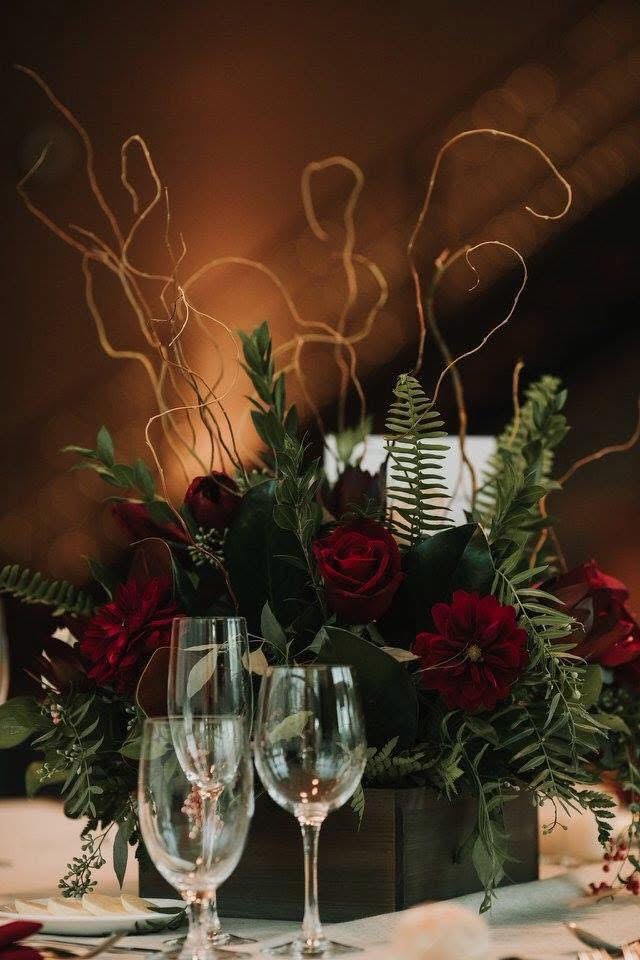 Burgundy rose and dahlia centerpiece with ferns and curly willow branches