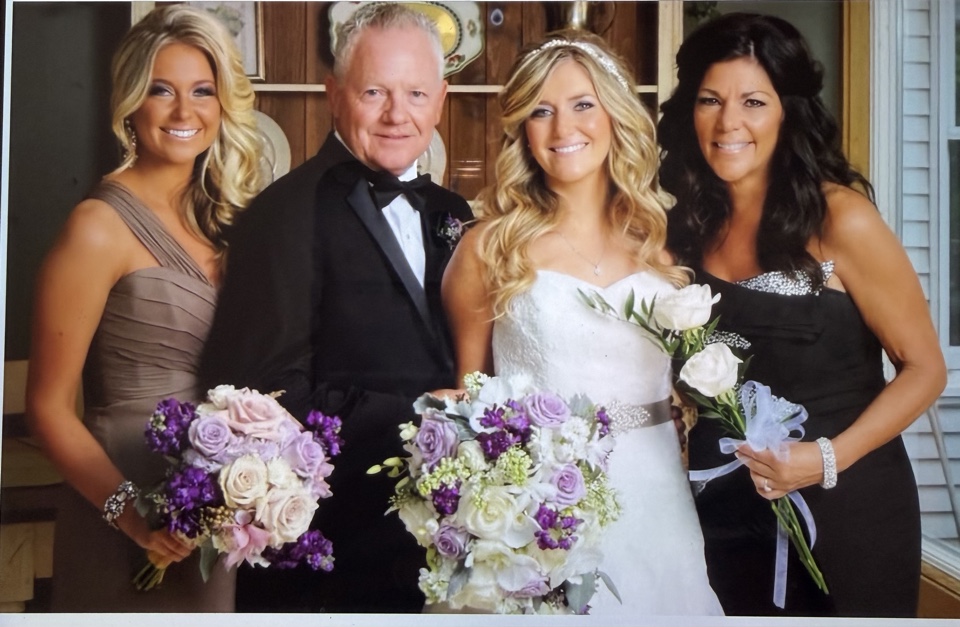 Bride with her family holding lavender and white rose bouquets with matching wrist corsage