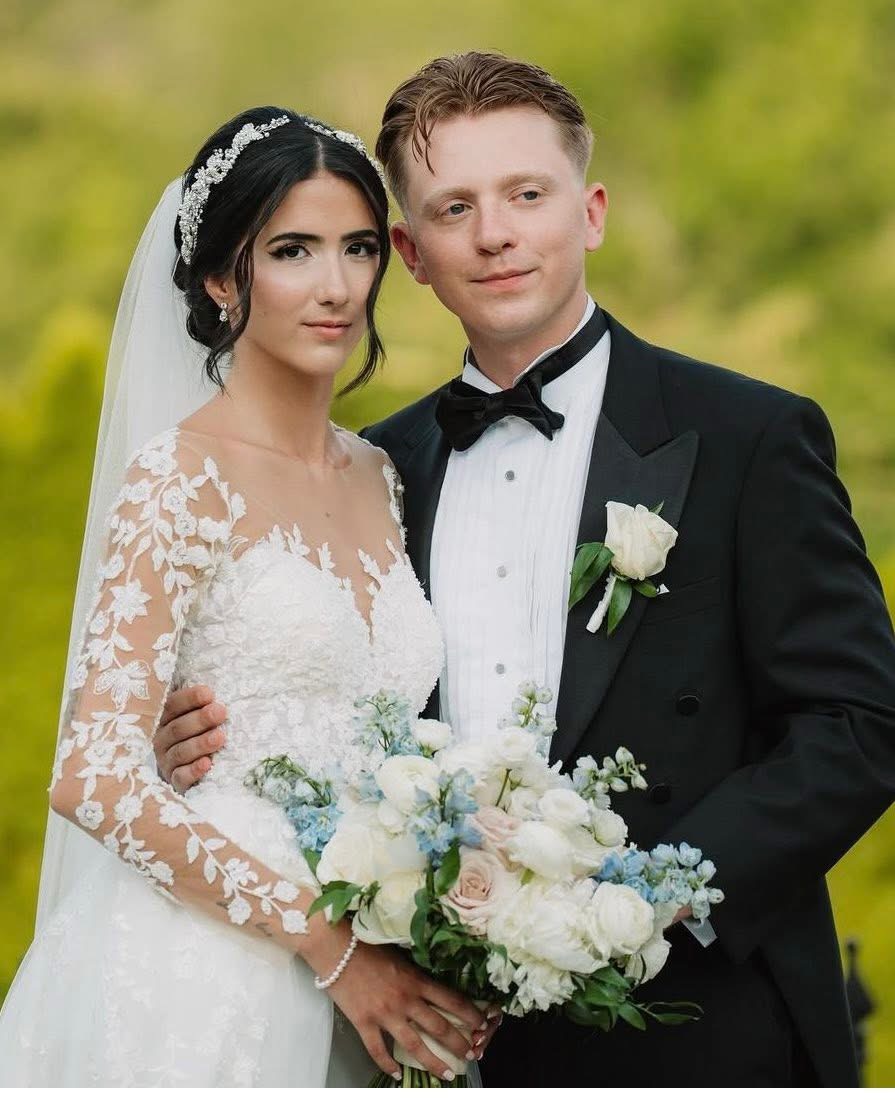 Bride and groom portrait with a white and blue bouquet of roses, delphinium and blush accents