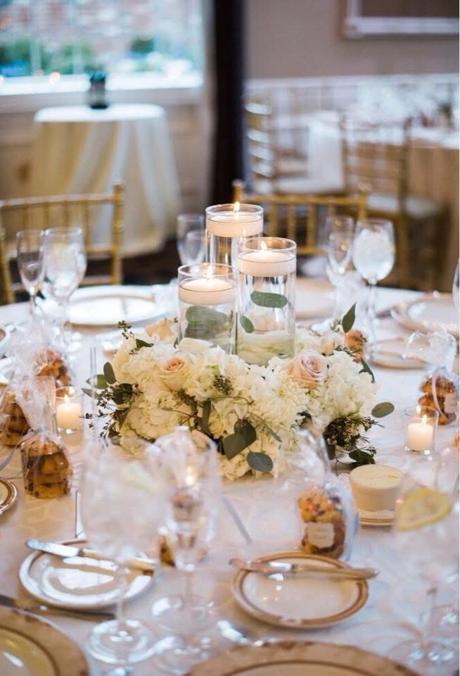Low white hydrangea and blush rose centerpiece ringed with floating candles