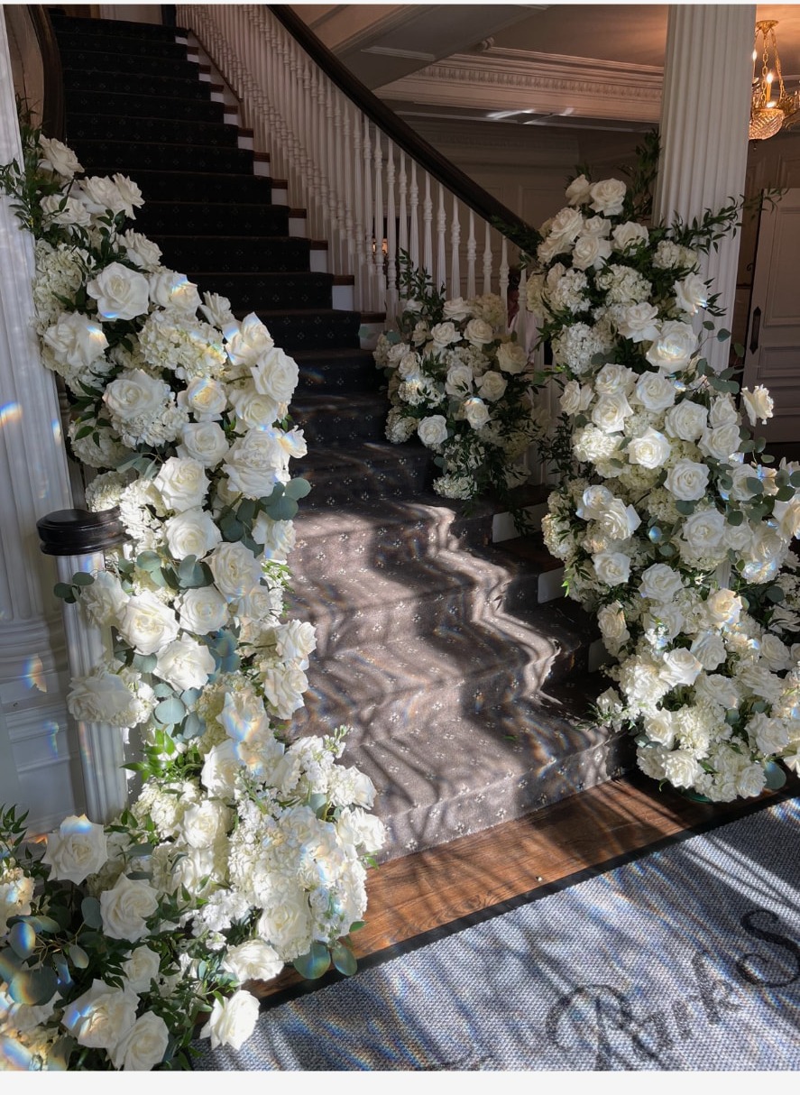 Estate entry staircase banked with white roses, hydrangea and eucalyptus on both sides