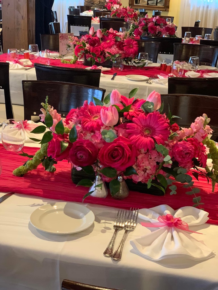 Head table run in fuchsia with lush centerpieces of hot pink gerberas, roses, tulips and hydrangea