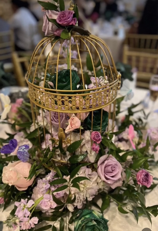 Gold birdcage centerpiece wrapped in lavender, blush and emerald roses with lush greenery