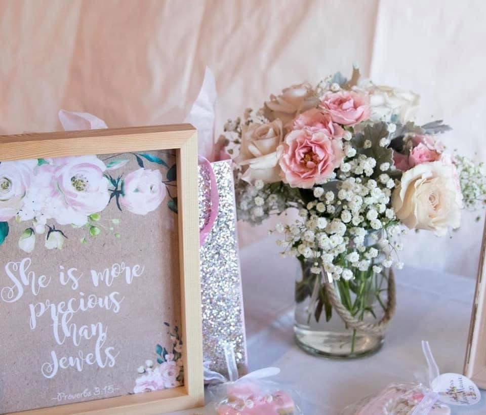 Mason jar of blush garden roses and baby's breath beside a She is more precious than jewels keepsake frame